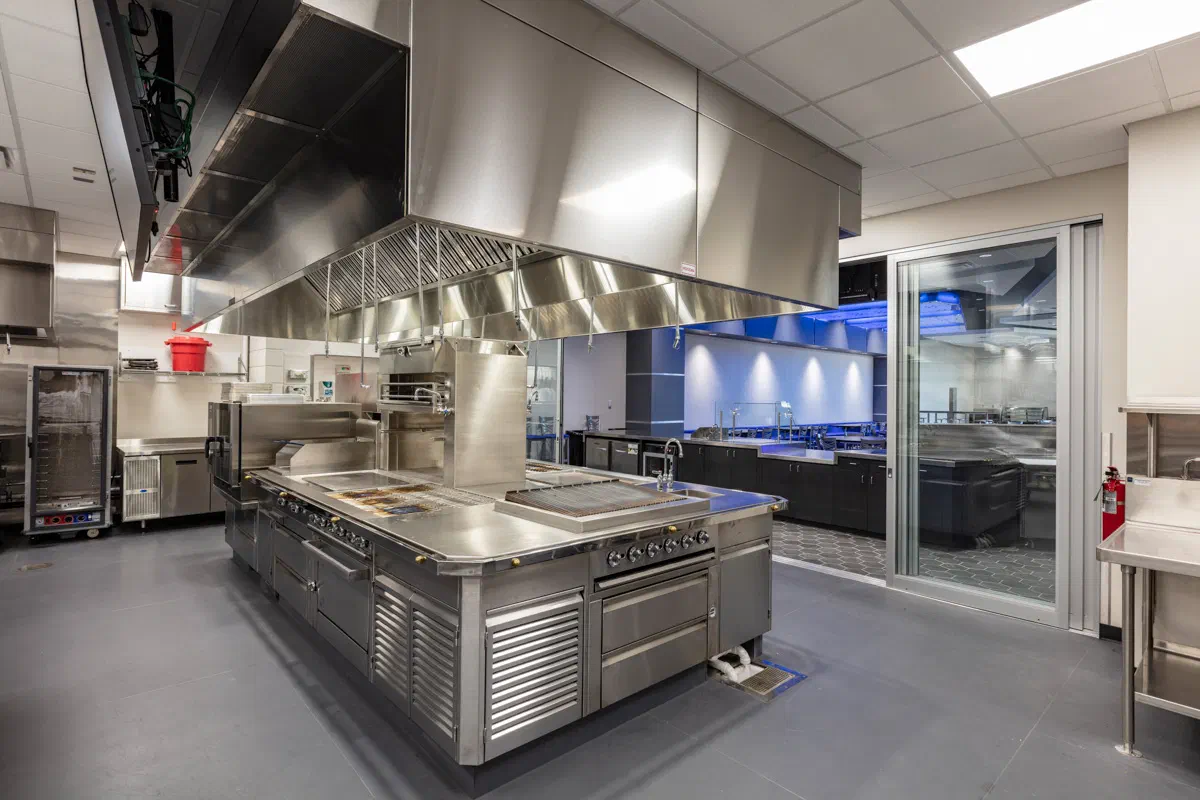 Autry Tech culinary arts teaching kitchen with stainless steel cooking line and exhaust hoods