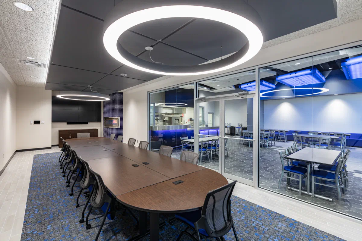 Culinary demonstration classroom with circular pendant light and glass-walled kitchen