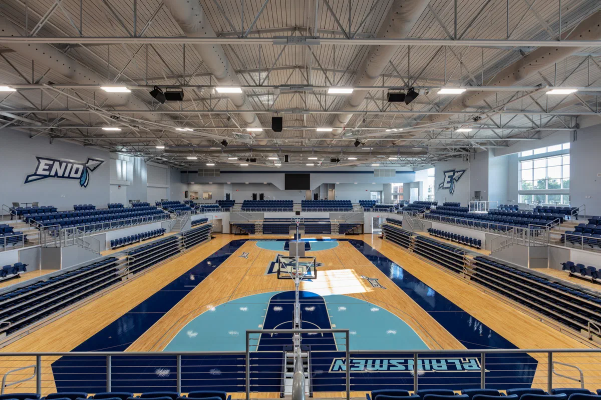 Enid High School competition gymnasium with Plainsmen court graphics and bleacher seating