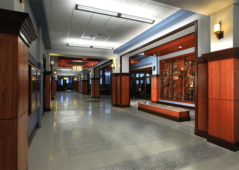 Renovated Enid High School hallway with polished concrete floors, wood paneling and display cases