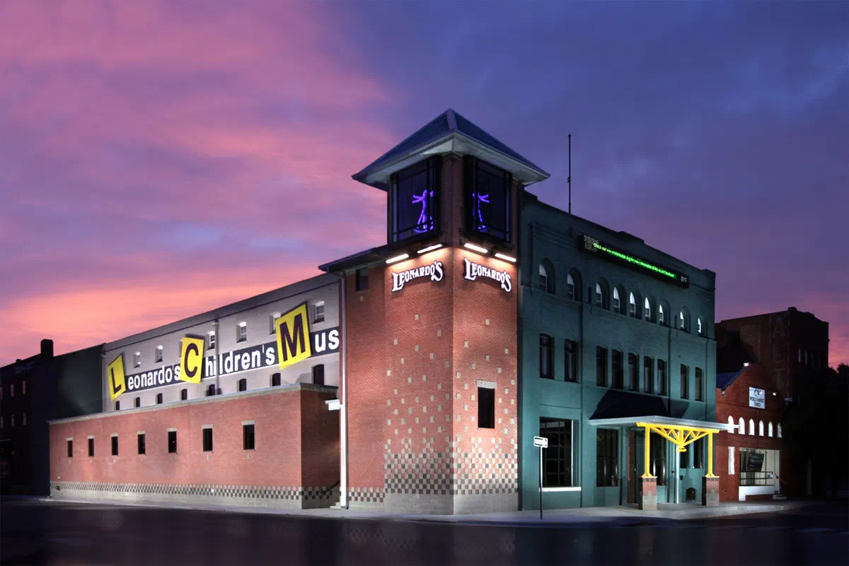 Leonardo's Children's Museum historic brick building with lighted tower at dusk
