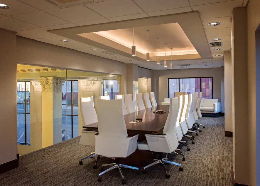Wymer Brownlee renovated meeting room with coffered ceiling, conference table and white leather chairs
